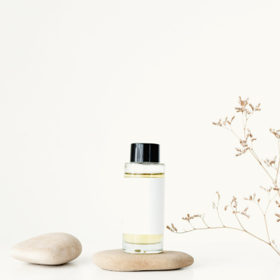 A small bottle of essential oils placed on a pebble